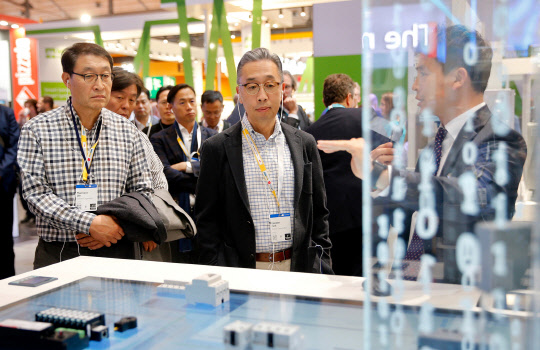 박지원 두산그룹 부회장(가운데)을 비롯한 경영진이 지난 1일(현지시간)부터 닷새 간 독일 하노버에서 열리는 하노버 메세 2019 전시회를 참관했다. 박 부회장이 독일 지멘스 전시관에서 발전용 사물인터넷 솔루션에 대한 설명을 듣고 있다.  두산 제공